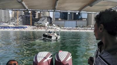 A sunken yacht being salvaged by its owner, Mohamed Irfan, and some volunteer divers off the beach on JBR. Antonie Robertson/The National