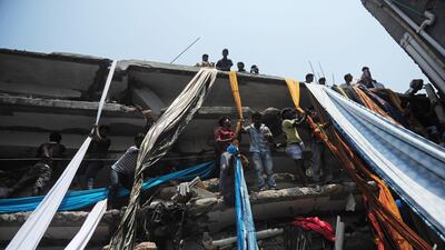 Bangladeshi garment workers use lengths of textile to evacuate from the rubble. AFP Photo / Munir uz Zaman