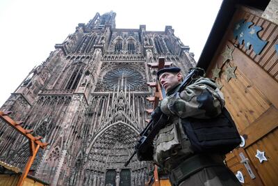 French soldiers stand guard at the Christmas market in front of the Cathedral, on December 12, 2018, as policemen conduct a search in order to find the gunman who opened fire near a Christmas market the night before, in Strasbourg, eastern France. Hundreds of security forces were deployed in the hunt for a lone gunman who killed at least two people and wounded a dozen others at the famed Christmas market in Strasbourg, with the French government raising the security alert level and reinforcing border controls. / AFP / Patrick HERTZOG