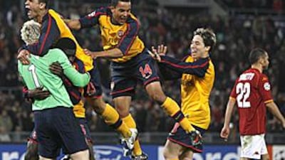 The Arsenal goalkeeper Manuel Almunia, left, is mobbed by teammates after helping his side win the shoot-out.