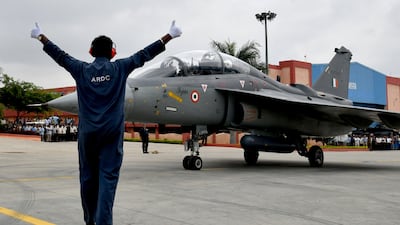 A marshal guides the Tejas light combat aircraft carrying Indian Defence Minister Rajnath Singh preparing to take off on a sortie at HAL Airport in Bangalore. All photos: AFP