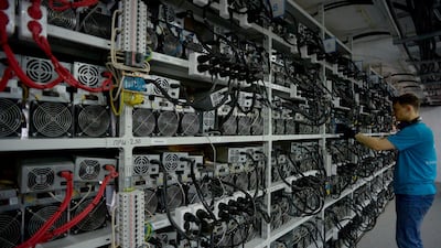 An employee inspects machines for the production of bitcoins at a mining centre in Kirishi, Russia. AFP