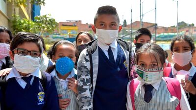 Colombian students pose for a picture wearing face masks made of recyclable and biodegradable materials, as a form of protest against the shortage of face masks in pharmacies, at Julio Cesar Turbay school, in Soacha, Colombia, on March 11, 2020. AFP