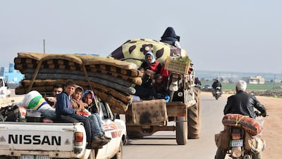 Civilians fleeing the city of Afrin in northern Syria are seen on the back of a pick up truck as they enter the town of Tal Rifaat in the government-controlled part of the northern Aleppo province, on March 18, 2018. George Ourfalian / AFP