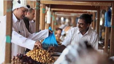 A shopper buys dates for Ramadan at the fruit and vegetable market in Sharjah.