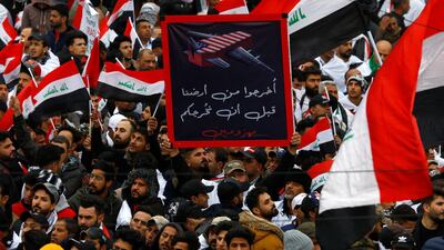 Supporters o fMoqtada Al Sadr hold a sign reading "Get out of our land before you leave defeated" at a protest. Reuters