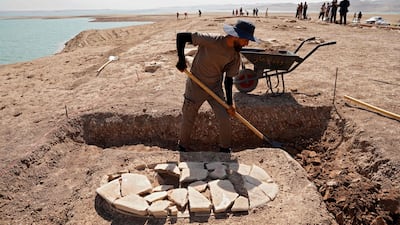 A Kurdish member of the Dohuk Antiquities Department works on a grave