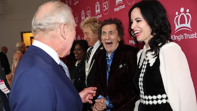 Britain's King Charles III speaks to Rolling Stones guitarist Ronnie Wood and his wife Sally as he arrives at London's Royal Albert Hall to celebrate the 50th anniversary of his youth charity The King's Trust. AFP