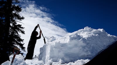 A resident shovels snow off the roof of his house. EPA