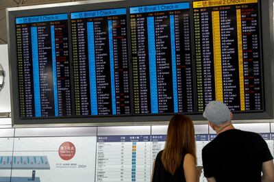Travellers check on information amid flight cancellations at the airport in Hong Kong. AP