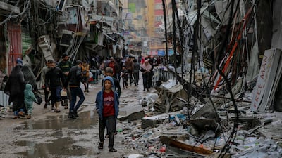 Palestinians walk amid debris of buildings hit in Israeli strikes, near Al-Zawiya market in Gaza City. AFP