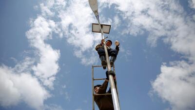 A man paints a solar street lamp in the suburbs of Pyongyang. Reuters