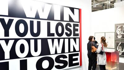 Visitors look at the artwork of Barbara Kruger at Art Basel in June 2018. The 2021 fair will be postponed until September, organisers have confirmed. Getty Images
