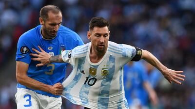 Italy defender Giorgio Chiellini holds on to Lionel Messi. AFP