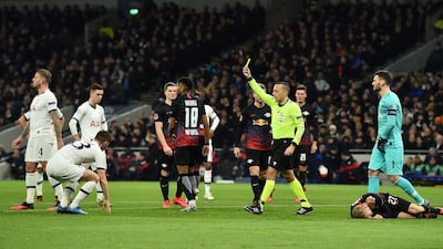 Referee Cuneyt Cakir shows a yellow card to Tottenham defender Ben Davies for his foul on Konrad Laimer that led to the penalty. AFP