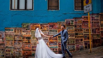A couple pose for wedding photos in the Central district of Hong Kong. ISAAC LAWRENCE / AFP