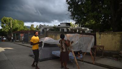 A woman prepares her tent to sleep outside of her house in Gros Morne. AFP