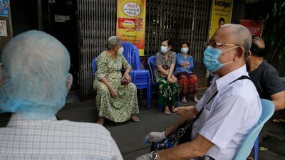 Elderly people wait to cast their ballots during early voting at a polling station in Yangon. EPA