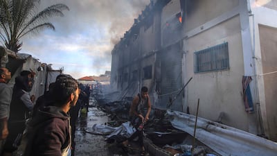 Palestinians try to extinguish a fire at an UNRWA vocational training centre in Gaza that is currently housing hundreds of displaced people. AP