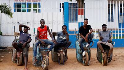 Men on wheelbarrows in Bissau, the capital of Guinea-Bissau, during an official visit by French President Emmanuel Macron. AFP