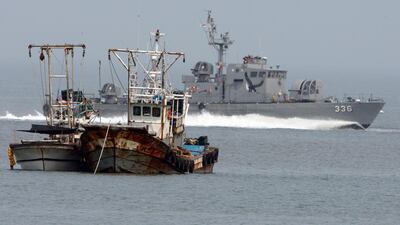 A South Korean navy vessel passes North Korean fishing boats. AP