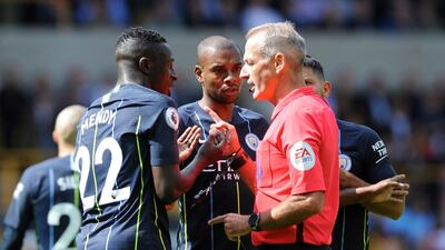 Referee Martin Atkinson talks with Manchester City's Benjamin Mendy, left, and Fernandinho. AP Photo