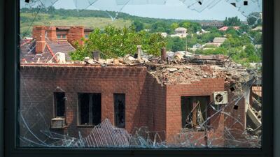 A house heavily damaged by Russian shelling is seen through a broken window, in the town of Bakhmut, Donetsk region. AP