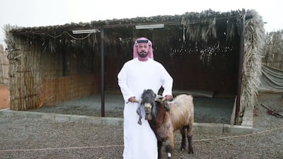 Emirati farmer Nasser Al Alwi with his billy goat who has started to produce milk. Anas Kanni / Al Ittihad