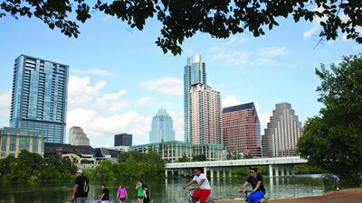 Cyclists on the Lady Bird Lake trail, with Austin’s downtown skyline in the background. The city ditches cars in favour of other transport. Julia Robinson / Reuters