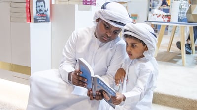 Young visitors enjoying a book at the Abu Dhabi International Book Fair, one of the region’s largest literary events. Ruel Pableo for the The National