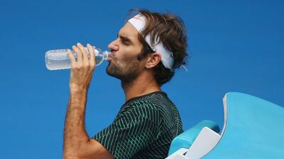 Roger Federer takes a drink break during a practice session. Michael Dodge / Getty Images