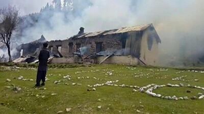 A man watches smoke rising from an empty burning building, where a Pakistani army helicopter crashed in the country's Nalter Valley on May 8, 2015. AP Photo