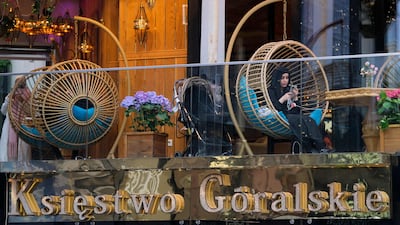 Tourists sit on a hotel balcony in Krupowki