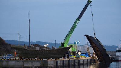 A wooden boat is craned out of the water at a port in Wajima in Ishikawa prefecture, central Japan. Mystery surrounds a fleet of ghost boats with headless skeletons or rotting corpses on board that are washing up on Japan’s shores. Jiji Press / AFP Photo