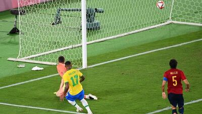 Brazil's Malcom Filipe scores past Spain's goalkeeper Unai Simon.