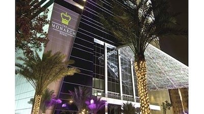 Lights shine on The Monarch Dubai's exterior at night.