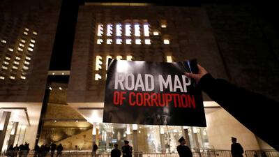 A demonstrator holds a sign during a protest outside the Parliament. Reuters
