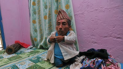 Chandra Bahadur Dangi, a 72-year-old Nepali who claims to be the world's shortest man at 56 centimetres (22 inches) in height, puts on a shirt in Jhapa district, southeastern Nepal. Pilloried by neighbours, laughed at in freakshows and spurned by the wome???