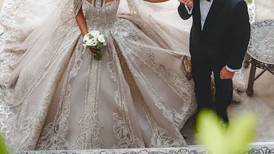 Saab Jr kisses his bride's hand at the ceremony.