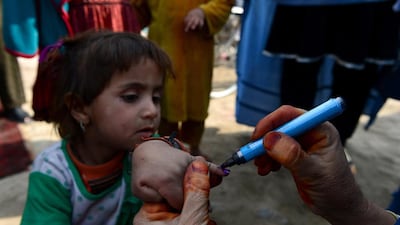 Afghan female health workers mark a child’s finger on February 24, 2014, after administering polio drops outside her house in Jalalabad in Nangarhar province. Wakil Kohsar / AFP photo