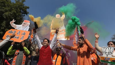 Supporters wave cut-outs of Indian Prime Minister Narendra Modi in Delhi on Saturday, as they celebrate the Bharatiya Janata Party's victory in local elections. EPA
