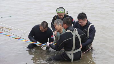 An elderly passenger is escorted to the riverbank after being rescued on June 2, 2015, from the passenger ship Dongfangzhixing or "Eastern Star", which sank in the Yangtze river in central China's Hubei province on Monday night. Agence France-Presse