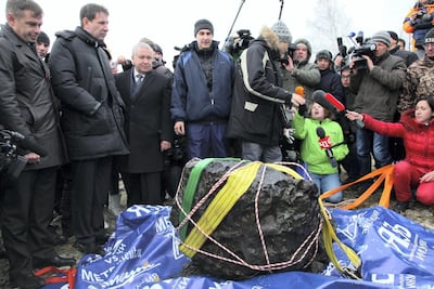 TV crews and officials gather by a meteorite recovered from Chebarkul Lake near Chelyabinsk in 2013. AP