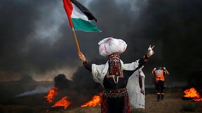 A woman holds a Palestinian flag during protests at the Israel-Gaza border fence on September 14, 2018. Reuters