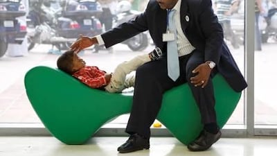 Mohammed Hassan, of Abu Dhabi, checks on his sleeping son, Hassan Mohammed, three, as he sleeps during the conference in Dubai.