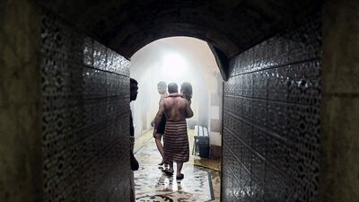 A man carries a child inside the traditional Turkish bathhouse.