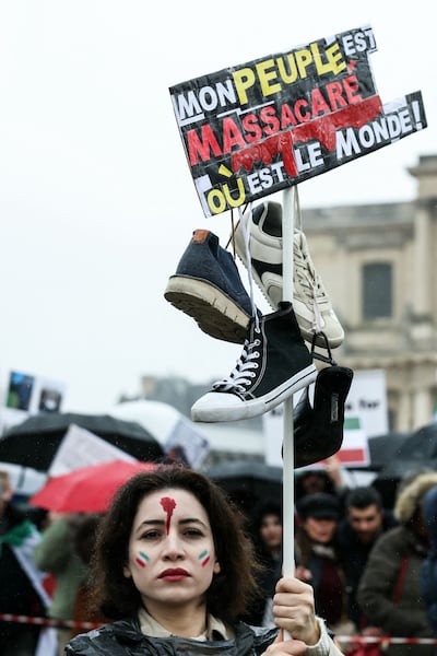 An Iranian woman in Paris holds the sign 'My people are massacred. Where is the world.' AFP