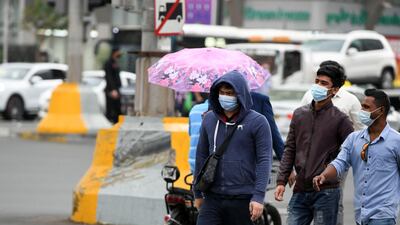 Umbrellas come out as rain begins to fall in Abu Dhabi. Khushnum Bhandari for The National
