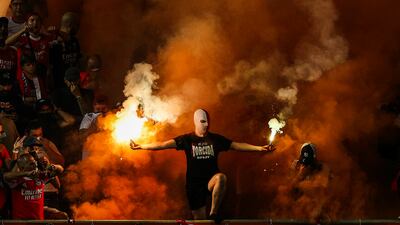 A supporter holds flares during the Portuguese Supercup soccer match between Sporting and Benfica at Algarve Stadium, in Faro, Portugal. EPA