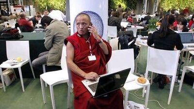 A Tibetan monk talks on his mobile phone and works on his laptop computer at the UN Climate Change Conference 2009 in Copenhagen December 9, 2009. Reuters / Bob Strong